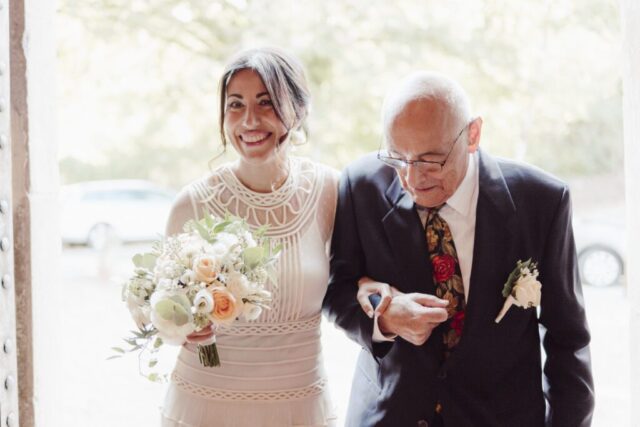 Entrata sorridente della sposa in chiesa con il papà sottobraccio