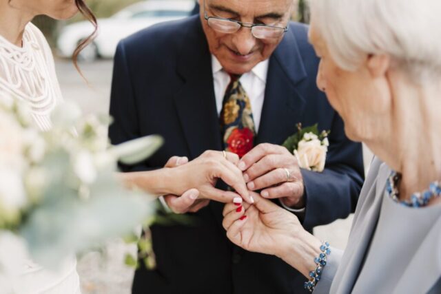 Lo sguardo dei genitori della sposa che guardano ammirati l'anello al dito della figlia