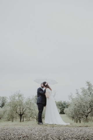 Bacio degli sposi sotto ombrello bianco