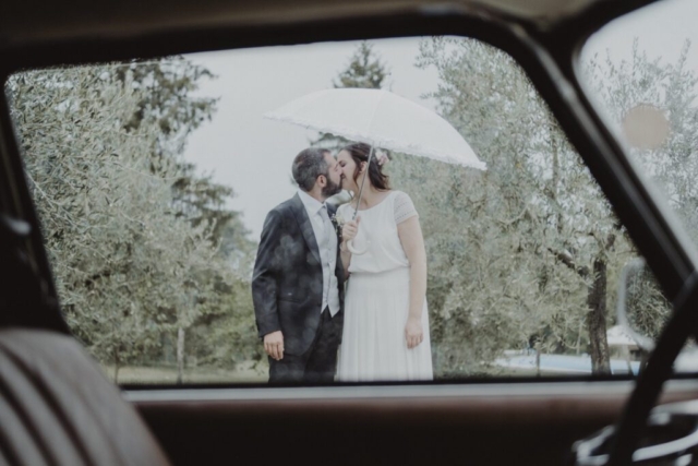 Bacio degli sposi sotto la pioggia
