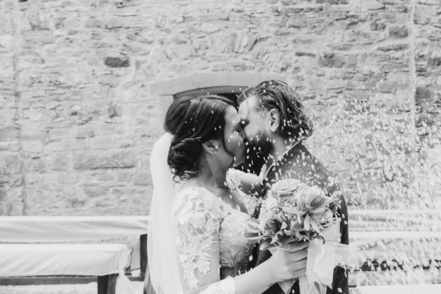 Bacio con lancio del riso per gli sposi